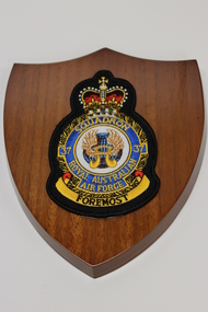 A wooden shield with a cloth insignia badge 37 Squadron Royal Australian Air Force with the words "Foremost" on the bottom in black 