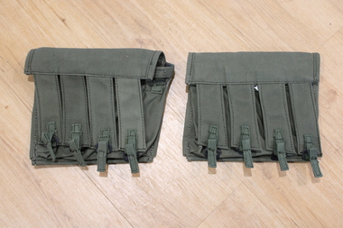 Two olive green pouches, each with small rectangular finger-like pouches for storing rounds of high-power ammunition.
