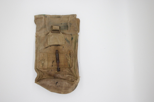 Rectangular brown canvas pouch with gusset sides and top flap that clips shut. Brass clips present to attach it to webbing or clothing are quite rusty.