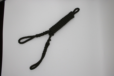 Coiled dark-coloured rope with a loop at each end. Single loop at one end and a double loop at the other end.