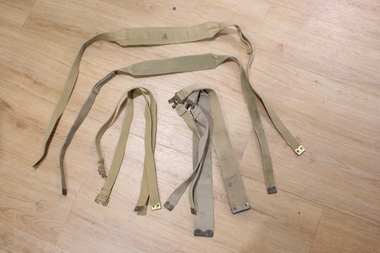 Six pieces of woven strapping that can be connected to each other in various ways with brass fittings.