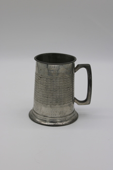 A tankard with an embossed design and personal engraving.
