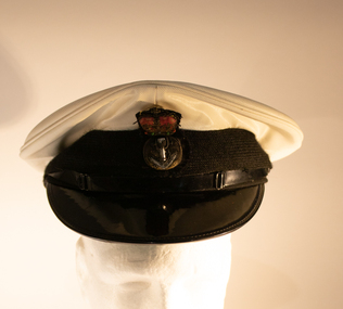A white navy cap with black peak with small badge in the centre.