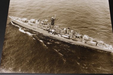 A sepia photograph of an aerial shot of HMAS Vampire at sea.