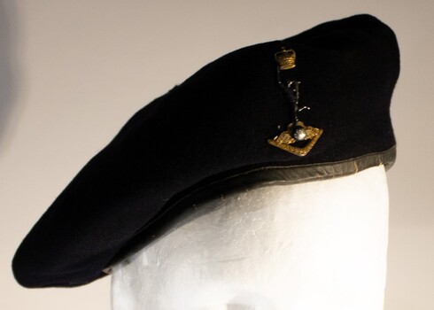 A dark blue service Corp beret issued to Royal Australian Signal Corp with had badge.