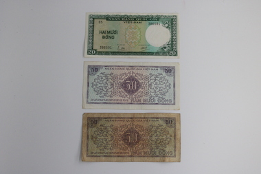 Three notes of Vietnamese money. Two @ 50 dong and 1 @ 20 dong.