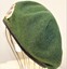 Green beret with a New Zealand Infantry Badge attached.