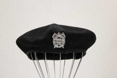 Black woollen beret with a silver badge-insignia of the Royal Australian Armoured Regiment as worn by tank drivers.