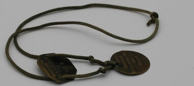 metal discs on cord identifying serviceman TJB Nicholson.