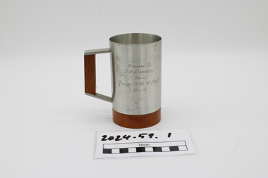 Pewter beer tankard with wooden base and handle insert and engraved dedication.