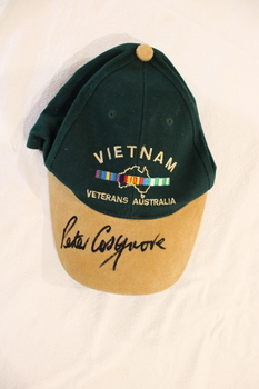 Peaked cap in tan and green signed by Peter Cosgrove.