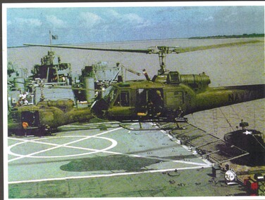 A coloured photo of US helicopters landing on an air craft carrier.