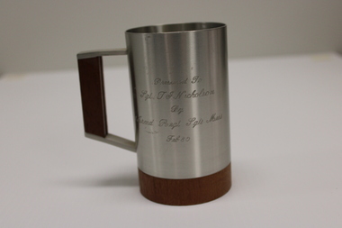Pewter beer tankard with  squared handle. Has a wooden base and handle insert, plus a dedication engraved on one side.