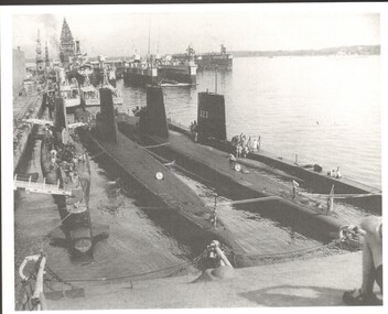 Black and white photo of Singapore Naval Base showing three submarines in the foreground.