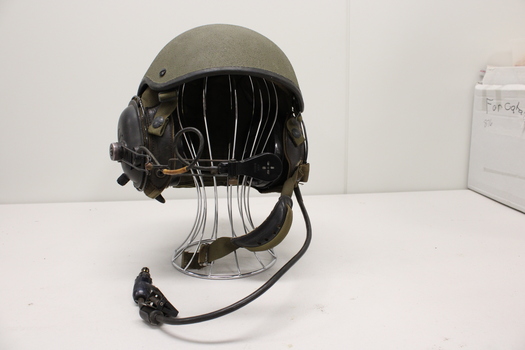Khaki coloured helmet with built in headphones with wireless attachments.
