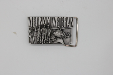 Belt buckle depicting 3 Vietnam Veterans and a helicopter.