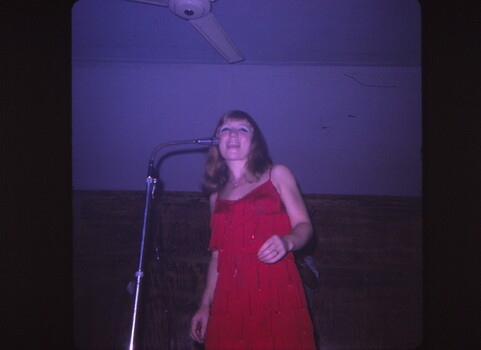 A coloured slide of a singer in a red dress.