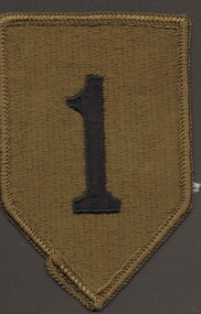 Shield shaped khaki cloth badge with the number 1 embroidered in black. Khaki overstitch on edges.