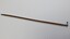 Wooden stick varnished with tarnished metal hilt with etched design that resembles mountains. Tip of stick is coloured black.
