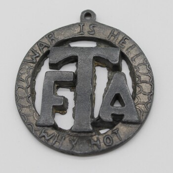Round Medallion with large FTA in middle, circled by inscription' War is Hell' at top/ 'Why Not' at bottom.