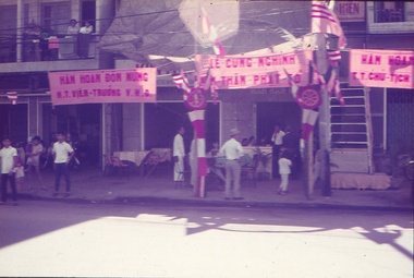 View of shops, shoppers and road.