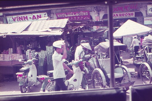 Street view - shops, mopeds and rickshaws.