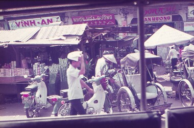 Street view - shops, mopeds and rickshaws.