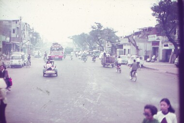 Busy road in Saigon, motorbikes, buses, bikes and cyclos.