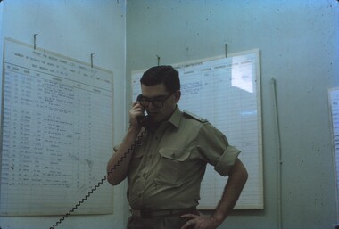 Lt Steve Phillips standing at desk on the phone.