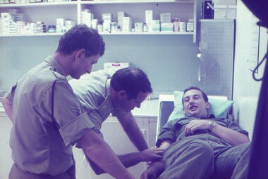Two medical staff examining a patient.