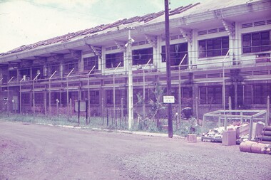 View of building behind barbwire fencing.