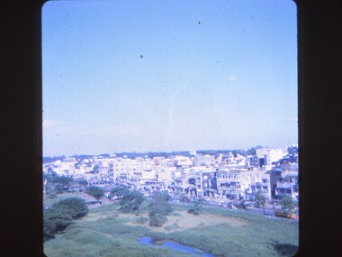 View of field, main road and buildings.