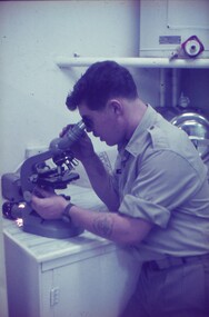 Cpl Egan looking into a microscope.