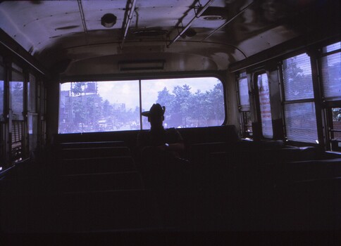 Photo taken inside bus with soldier in slouch hat silhouetted.