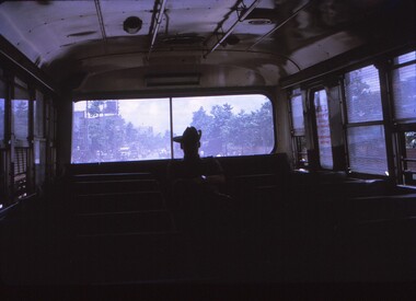 Photo taken inside bus with soldier in slouch hat silhouetted.