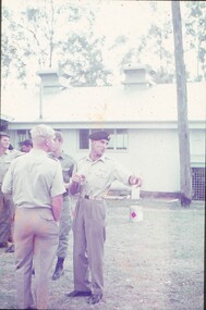 Military personnel standing on lawn.