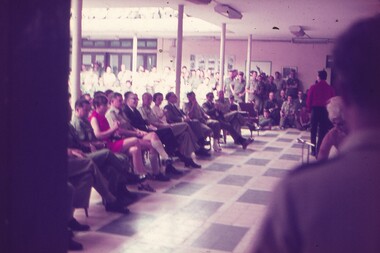 Military personnel sitting and standing watching a Christmas concert.