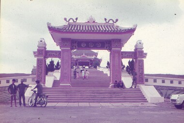 Vietnamese style arch leading up stairs, to a shrine for the fallen.