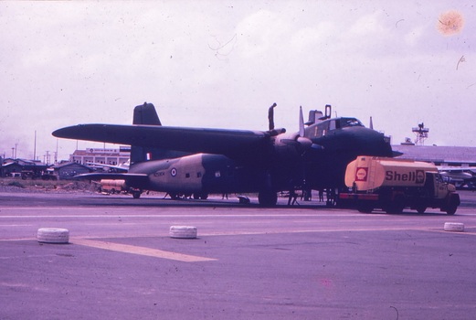A yellow Shell truck refuelling an aircraft on the tarmac.