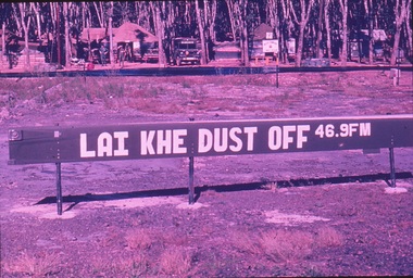 Wooden sign with white lettering 'Lai Khe Dust Off 48.9FM'