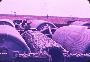 Inflatable buildings and fortified storage area covered with sandbags.