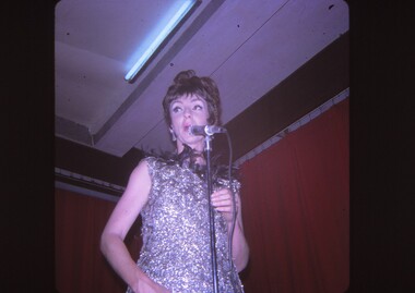 Female entertainer performing at microphone.