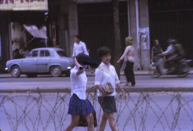 Students and locals walking on street.