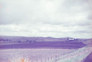 Scenery off side of road, hills in background.