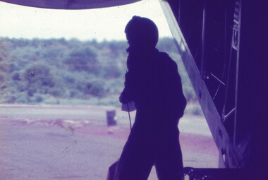 Silhouette of  aircraft personnel at opening of aircraft.