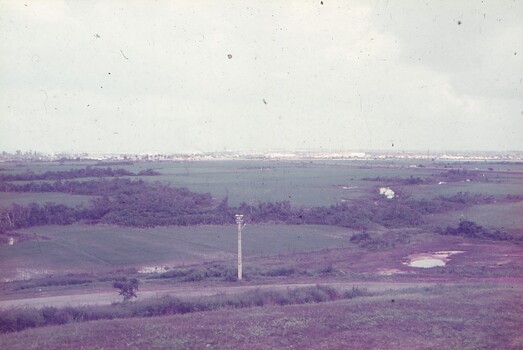 View of fields with city in far background.