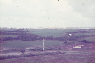 View of fields with city in far background.