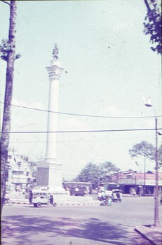 Statue on tall white column in centre of roundabout.