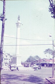 Statue on tall white column in centre of roundabout.