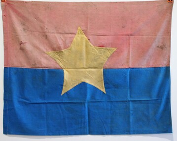 A Viet Cong flag. The top half is red and the bottom is blue and in the centre is a yellow star.